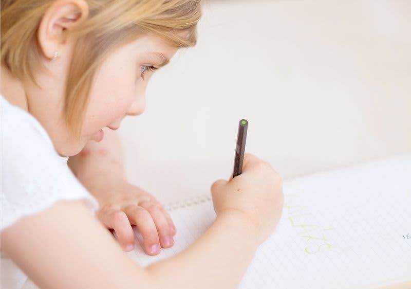 Ein junges Mädchen hält bei der U9-Untersuchung einen Stift