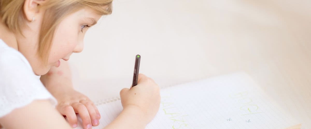 Ein junges Mädchen hält bei der U9-Untersuchung einen Stift