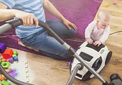 Mutter und Kind mit Staubsauger