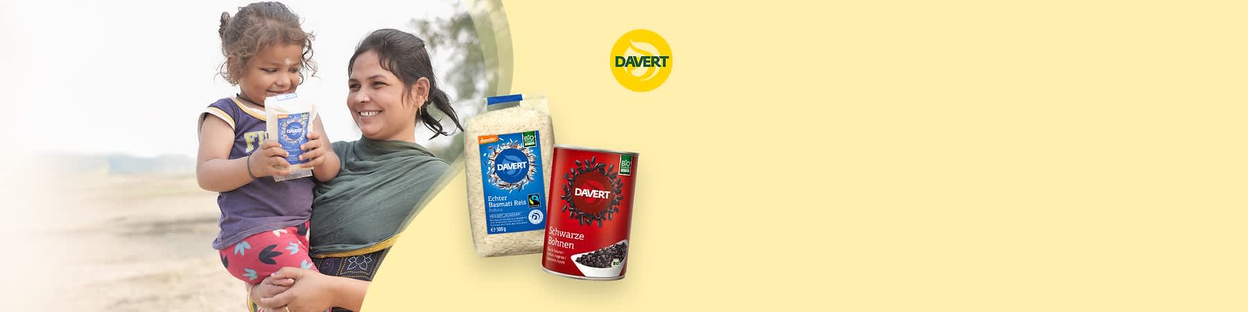 Eine Packung echter Basmati Reis von Davert mit blauem Etikett und eine Dose schwarze Bohnen von Davert mit rotem Etikett auf gelbem Hintergrund. Oben rechts das Logo von Davert.