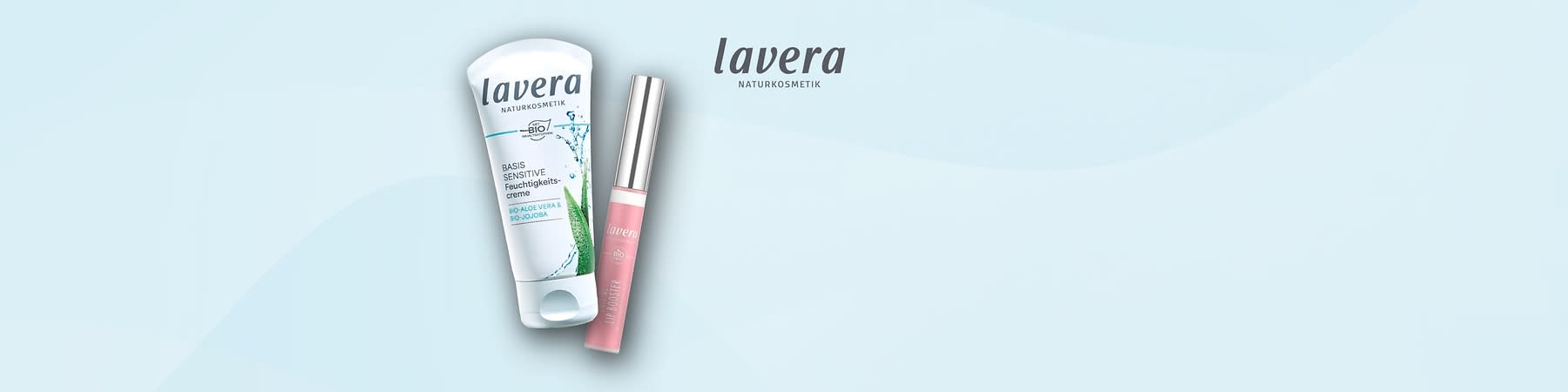 Eine Produktabbildung von Lavera Naturkosmetik zeigt eine weiße Tube mit der Aufschrift Basis Sensitiv Feuchtigkeitscreme Bio Aloe Vera Bio Jojoba und daneben einen rosafarbenen Lippenpflegestift mit der Aufschrift Lavera Bio Lipgloss auf einem hellblauen Hintergrund, oben rechts steht der Schriftzug lavera Naturkosmetik in dunkelgrauer Schrift.