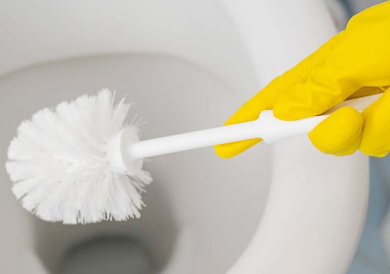 Toilette mit Schwamm und Putzmittel reinigen