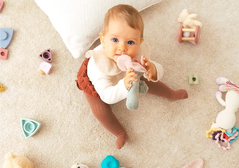 Baby mit Spielzeug im Mund