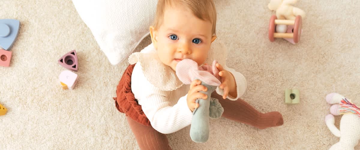 Baby mit Spielzeug im Mund