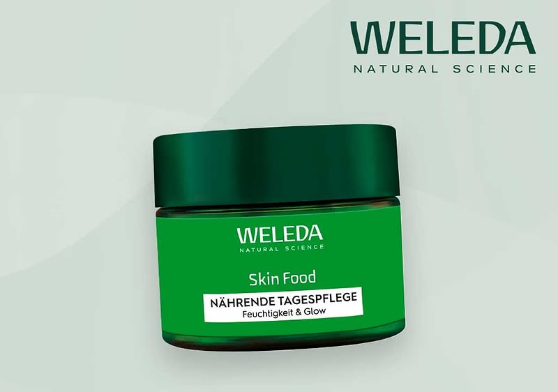 Eine grüne Cremedose mit der Aufschrift „WELEDA Skin Food Nährende Tagespflege Feuchtigkeit & Glow“ vor einem hellgrünen Hintergrund. Oben rechts steht „WELEDA Natural Science“.