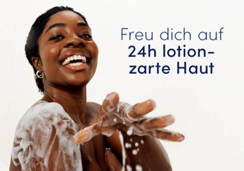Frau mit seifenschaum bedeckt, die eine eingeseifte Hand nach vorne hält; daneben Text „Freu dich auf 24h lotion-zarte Haut“