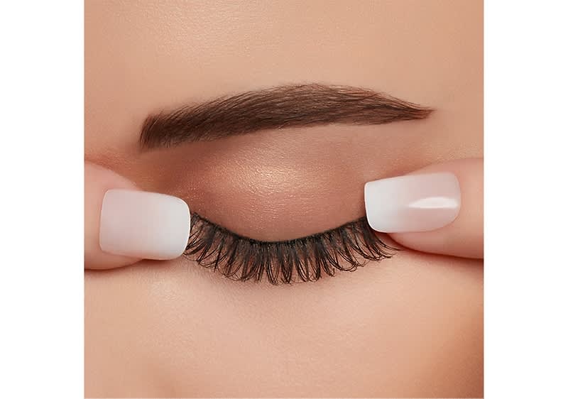Lege nun das Wimpernband mithilfe einer Pinzette am natürlichen Wimpernkranz an und drücke es leicht an.