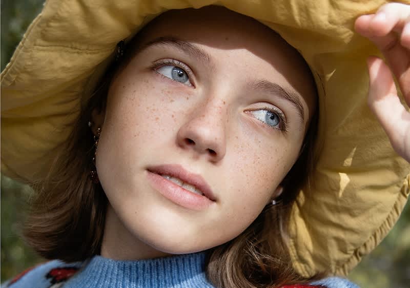 Junge Frau blickt in die Sonne