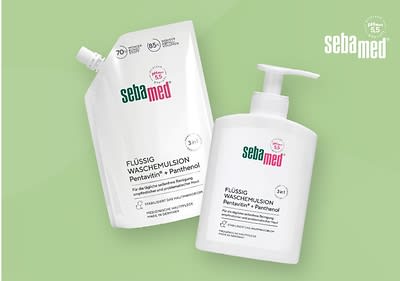 Zwei Sebamed-Produkte auf einem hellgrünen Hintergrund, links eine weiße Nachfüllpackung mit einem Schraubverschluss und rechts eine weiße Pumpflasche, beide mit der Aufschrift Flüssig Wasch-Emulsion und dem Hinweis auf den Inhaltsstoff Panthenol, oben rechts das Sebamed-Logo in Weiß
