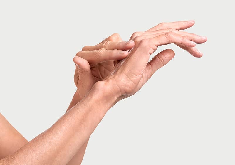 Ausschnitt der Hände, die sich gegenseitig durch Eincremen pflegen