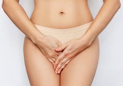 Frau liegt mit Wärmflasche im Bett