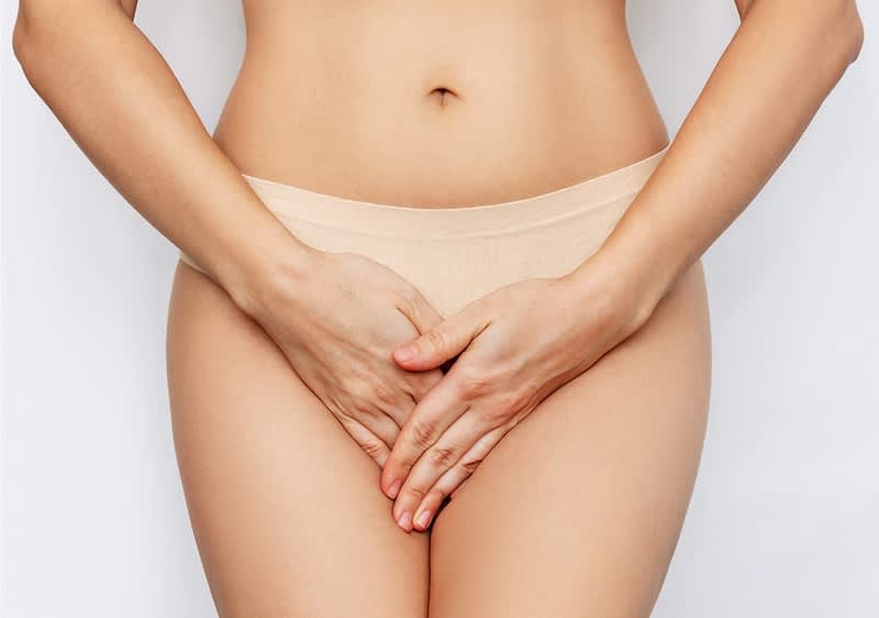 Frau liegt mit Wärmflasche im Bett