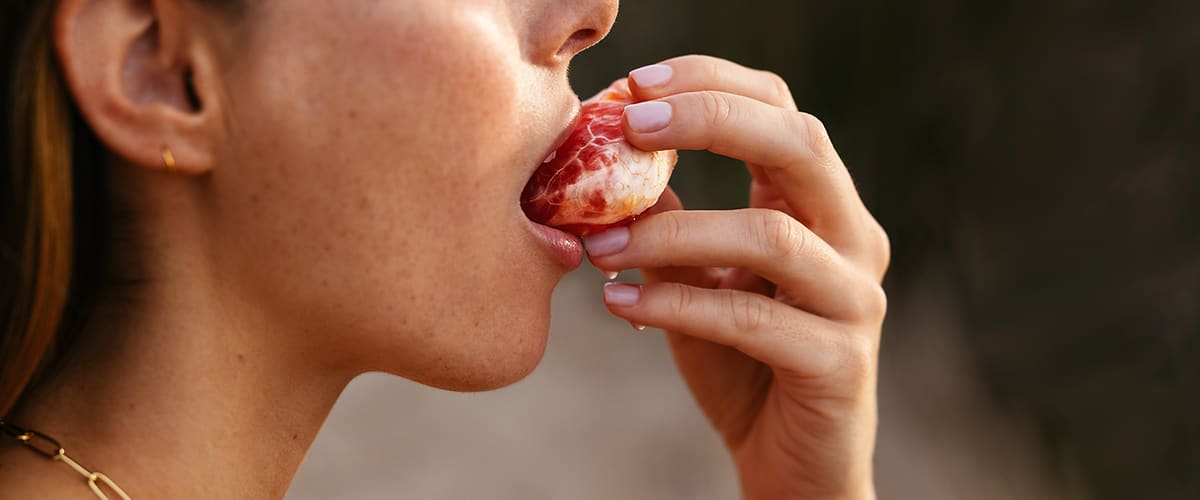 Frau beißt in Obst