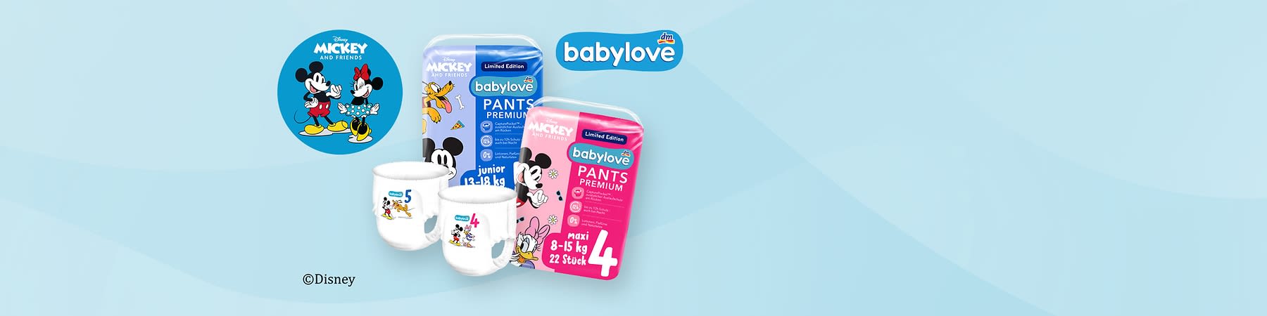 Zwei Packungen Babylove Premium Pants Windeln mit Disney-Motiven sind abgebildet, die linke Packung ist blau und zeigt Mickey Mouse mit einem Tiger, Größe 5 für 12-17 kg, die rechte Packung ist rosa und zeigt Minnie Mouse mit Blumen, Größe 4 für 9-14 kg, beide Packungen tragen das Disney Mickey and Friends Logo und das dm-Logo, daneben ein rundes Bild mit Mickey und Minnie Mouse, unten steht ©Disney