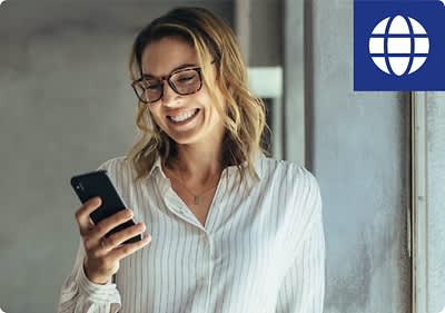 Frau mit Smartphone am Fenster