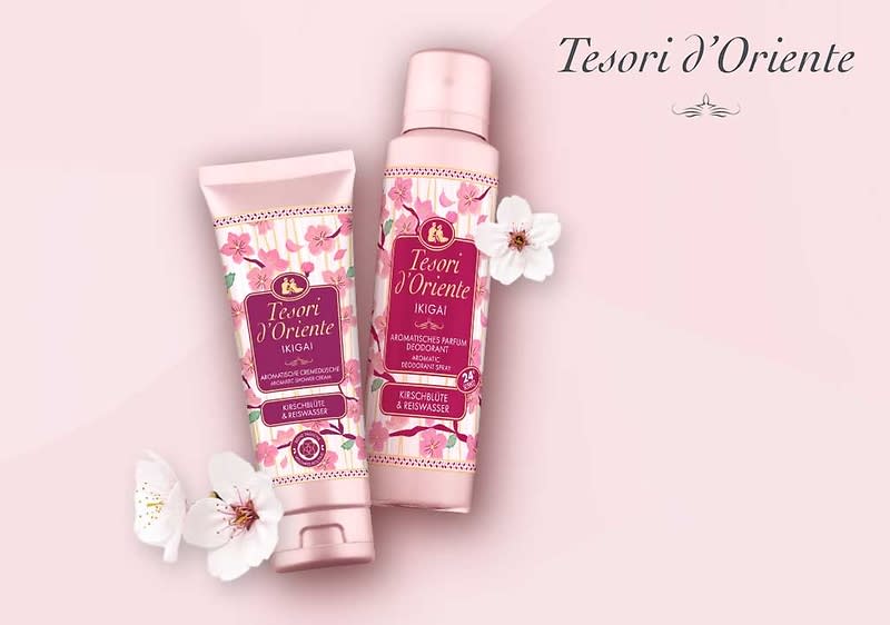 Zwei rosafarbene Produktverpackungen der Marke „Tesori d’Oriente“ mit Aufschrift „Yokai“ und floraler Gestaltung, eine Tube und eine Sprühflasche, dekorativ mit weißen Blüten auf hellem rosa Hintergrund