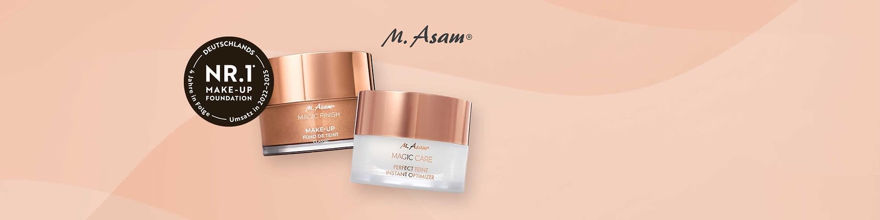Zwei Tiegel M. Asam Kosmetikprodukte in roségoldenen Deckeln, links „Magic Finish Make-Up“ in braunem Tiegel, rechts „Magic Care Perfect Teint Instant Optimizer“ in weißem Tiegel, dazu schwarzer Rundaufkleber mit Schrift „Deutschlands Nr.1 Make-Up Foundation“ und Jahresangabe 2022–2025