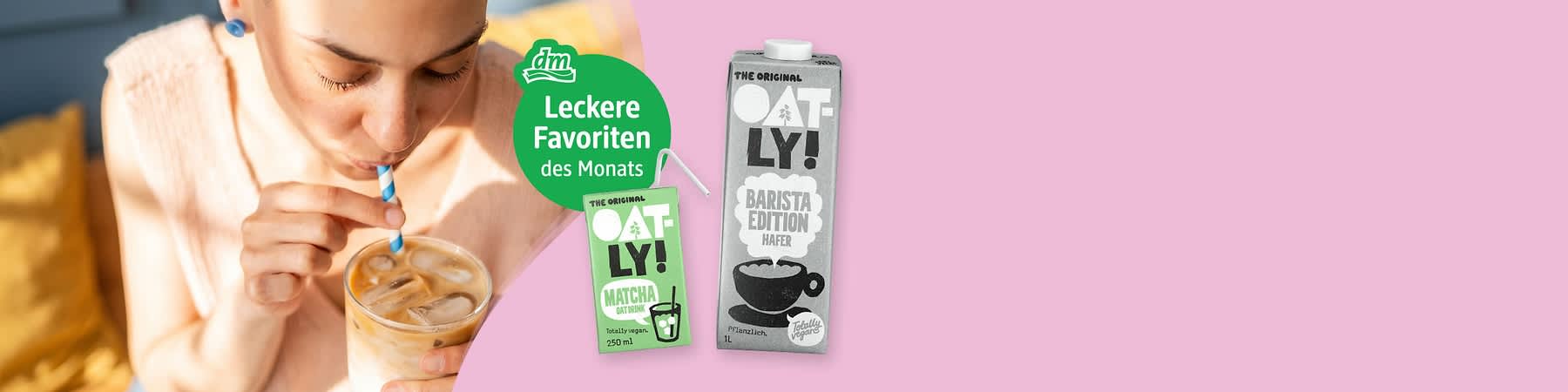 Frau trinkt mit blau-weiß gestreiftem Papierstrohhalm ein Glas Eiskaffee mit Eiswürfeln; daneben zwei Oatly-Packungen: grüne 250-ml-Packung „OATLY! Matcha Oat Drink“ und größere graue 1‑L-Packung „OATLY! Barista Edition Hafer“ sowie grüner Kreis mit weißer Schrift „dm Leckere Favoriten des Monats“. Bild mithilfe von KI erstellt