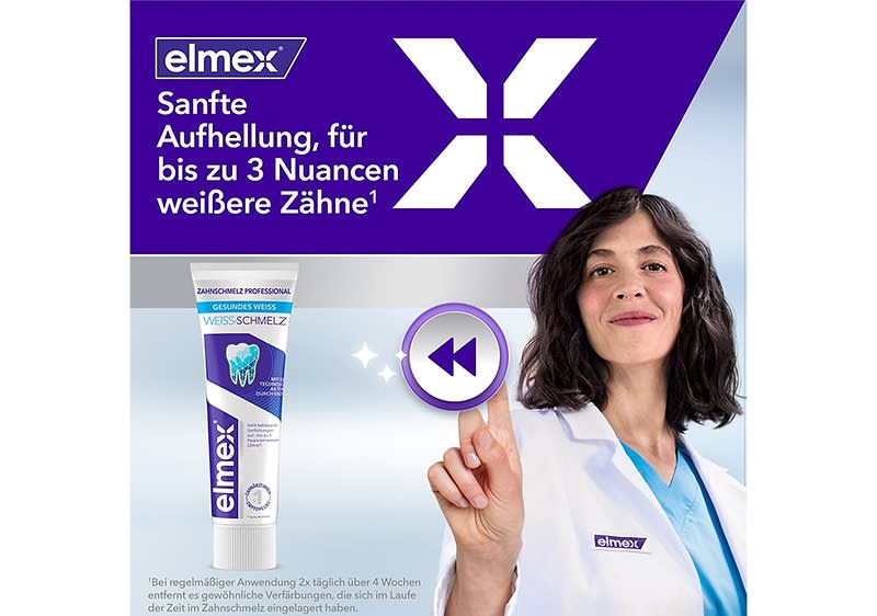 Produktverpackung der Zahnpasta Elmex mit der Aufschrift „Sanfte Aufhellung, für bis zu 3 Nuancen weißere Zähne“ und einem Bild der Zahnpasta-Tube, daneben eine Person in weißem Kittel mit Elmex-Logo, die auf ein Symbol zeigt