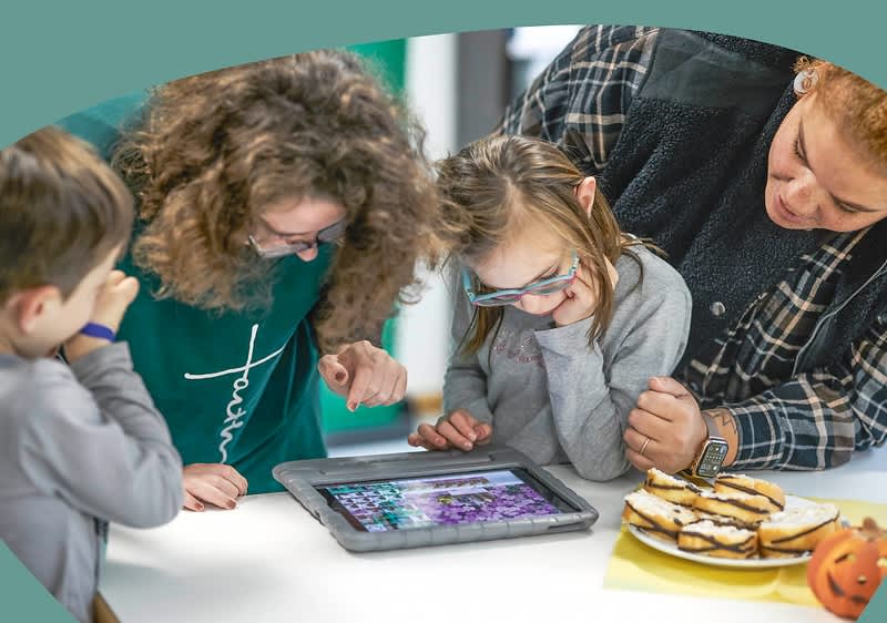 Familie schauen auf Tisch mit digitalen Medien