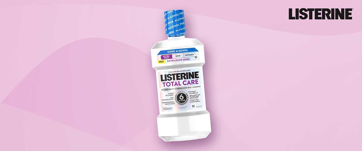 Weiße Flasche Mundspülung LISTERINE Total Care 500 ml mit blauem Verschluss, Aufschrift „Ohne Alkohol“, Hinweis „Extra milde Minze“ und schwarzem Markenlogo rechts oben