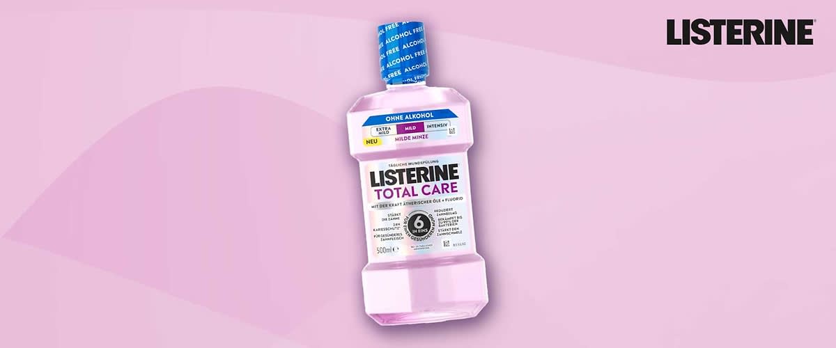 Eine rosa Listerine Total Care Mundspülung in 500-ml-Flasche mit Aufschrift „OHNE ALKOHOL“, blauem Verschluss und schwarzem Markenlogo „LISTERINE“ oben rechts
