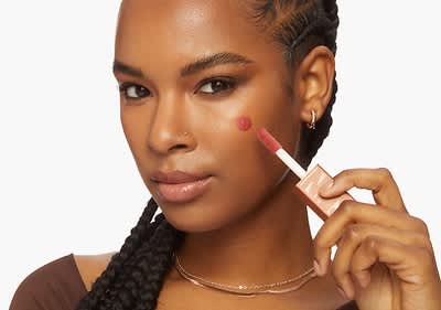 Den Sunkisser Blush mithilfe des XL-Plüsch Applikators auf die Wangen auftragen .