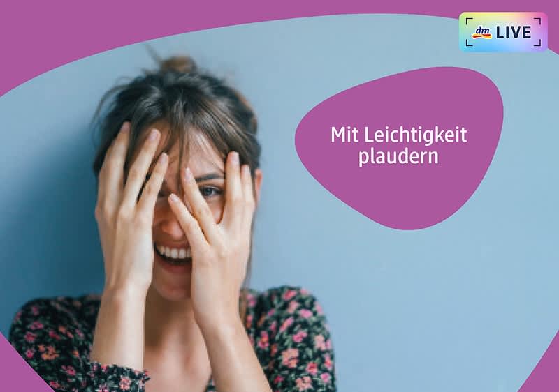 Eine Frau mit braunen Haaren, die zu einem lockeren Dutt gebunden sind, sitzt vor einer blauen Wand und hält ihre Hände vor ihr Gesicht, sie trägt ein geblümtes Oberteil, rechts oben im Bild steht in einem lila Feld der Text Mit Leichtigkeit plaudern und daneben befindet sich das dmLIVE-Logo mit einem kleinen Regenbogenrahmen.