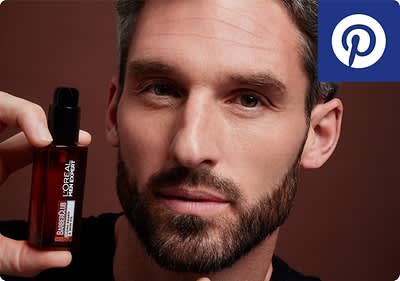 Mann hält L'Oréal-Serumflasche