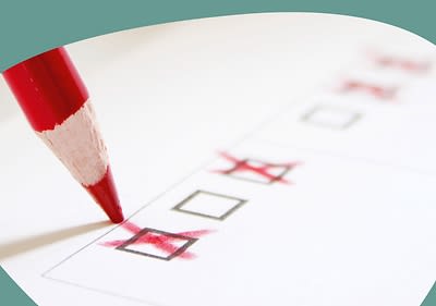 Ein roter Stift der ein Kreuzchen setzt