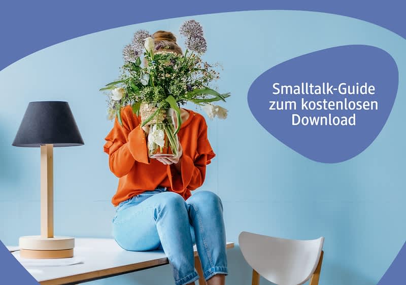 Frau sitzt mit Blumen auf dem Tisch und versteckt ihr Gesicht