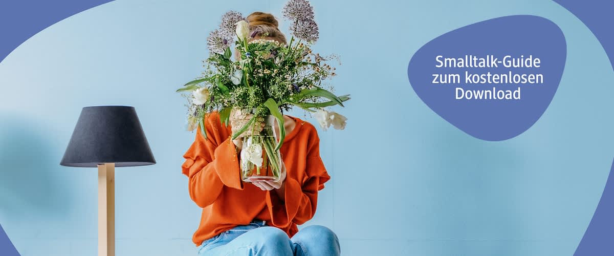 Frau sitzt mit Blumen auf dem Tisch und versteckt ihr Gesicht