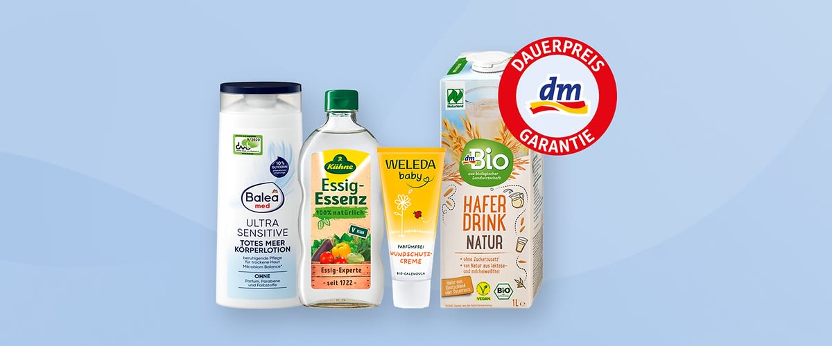 Vier Produkte vor einem blauen Hintergrund, von links nach rechts: Eine weiße Balea med Flasche mit der Aufschrift „Ultra Sensitive Totes Meer Körperlotion“, eine Flasche Kühne Essig-Essenz mit grünem Deckel und der Aufschrift „Essig-Experte seit 1722“, eine Tube Weleda Mundschutzcreme mit der Aufschrift „Happy Orange“, eine Packung dm Bio Haferdrink Natur mit der Aufschrift „Haferdrink Natur“ und einem grünen Bio-Siegel, oben rechts ein rotes dm Dauerpreis Garantie Logo