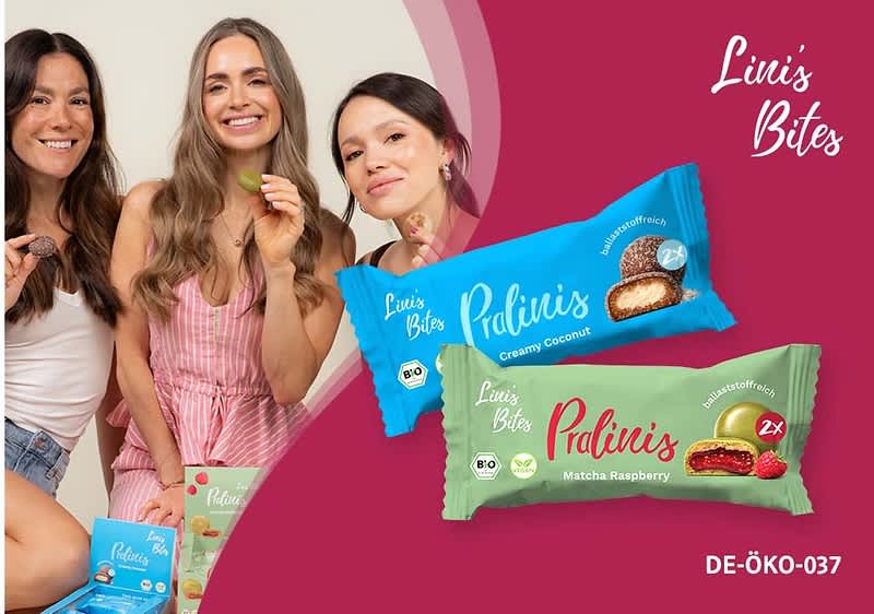 Drei lächelnde Frauen sitzen links, rechts zwei Produktverpackungen von „Lini’s Bites Pralinis“ überlagern das Bild: eine blaue Verpackung mit Aufschrift „Creamy Coconut“ und eine grüne Verpackung mit Aufschrift „Matcha Raspberry“, unten rechts Kennzeichnung „DE-ÖKO-037“