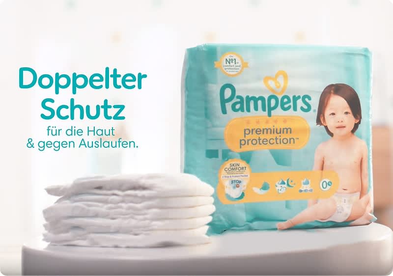 Ein Baby hält eine Packung Pampers Premium Protection.