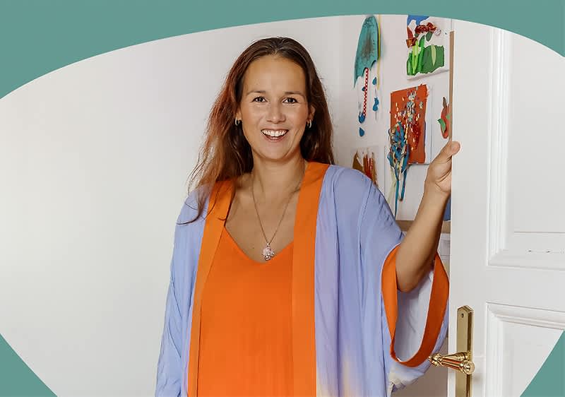 Frau in bunter Kleidung öffnet Tür