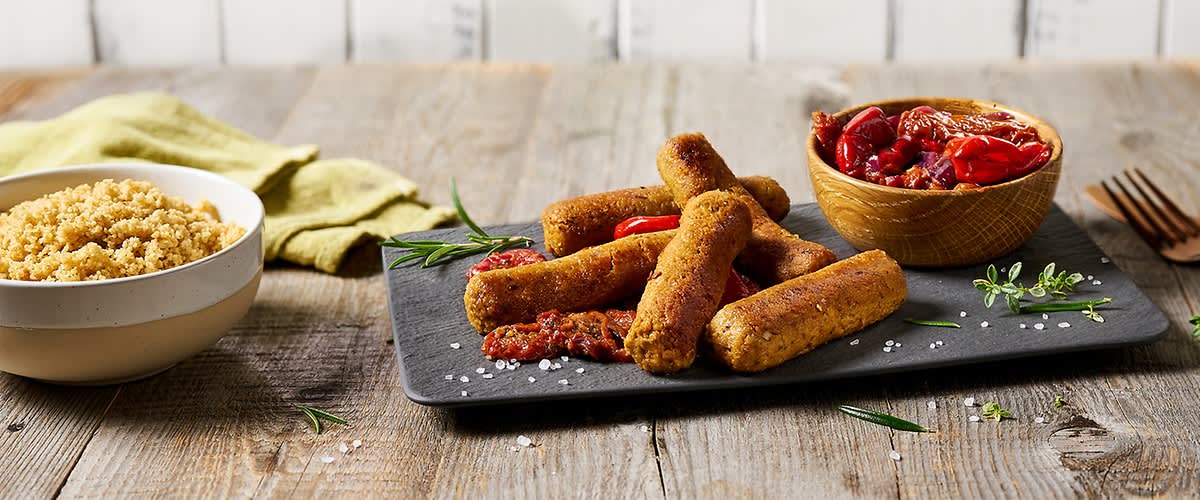 Vegane „Cevapcici“ mit rotem Zwiebelgemüse und Paprika 