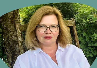 Frau sitzt auf Holzstuhl im Garten