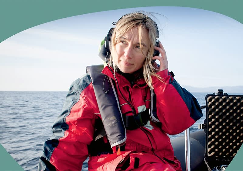 Person in roter Jacke auf Boot