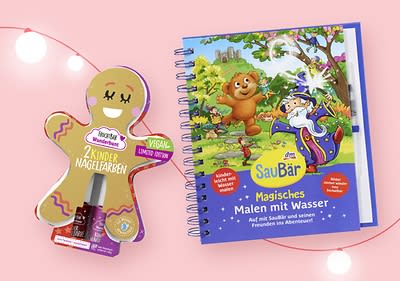Eine Verpackung in Form eines Lebkuchenmanns enthält zwei vegane Kinder-Nagellacke, daneben ein Kinderbuch mit dem Titel „SauerBär Magisches Malen mit Wasser“ mit einem fröhlichen Bären und einem Zauberer auf dem Cover