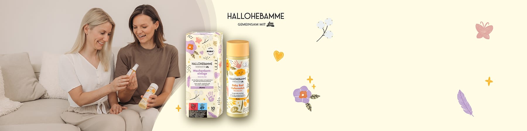 Zwei lächelnde Frauen betrachten gemeinsam eine kleine Flasche, daneben stehen eine bunt gemusterte Packung „Hallo Hebamme Wochenbett-Einlage Mamas“ und eine gelb-weiß gestaltete Flasche „Hallo Hebamme Baby Bad Hafermilch“
