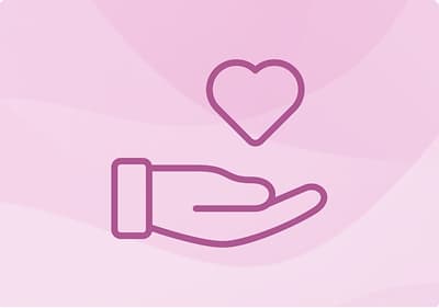 Hand hält Herz auf rosa Hintergrund