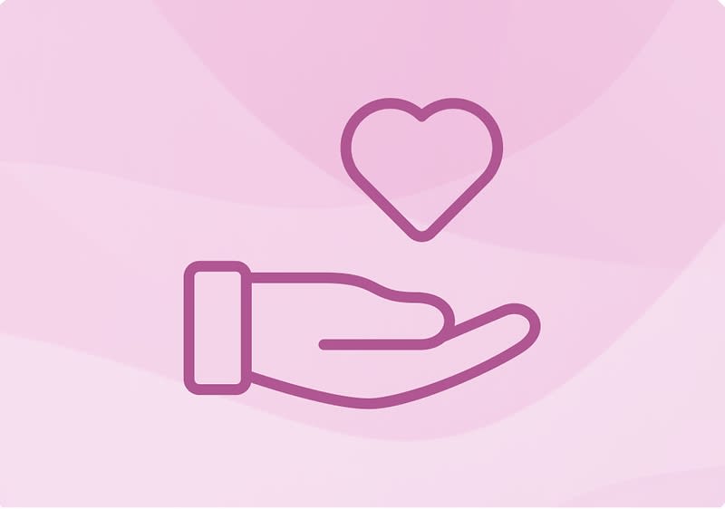Hand hält Herz auf rosa Hintergrund