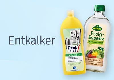 Eine gelbe Flasche Denkmit Entkalker neben einer Flasche Kühne Essig-Essenz mit der Aufschrift „100% natürlich“