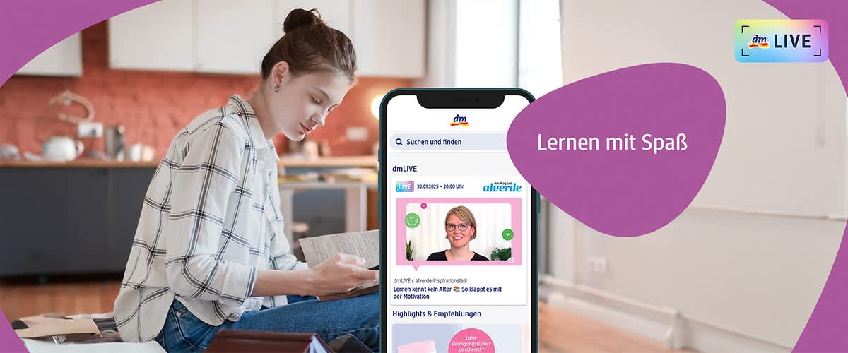 Eine Frau mit braunem Haar, das zu einem Dutt gebunden ist, sitzt in einem Raum mit einer Küche im Hintergrund und liest ein Buch, während sie auf einem Stuhl sitzt; sie trägt ein kariertes Hemd und blaue Jeans, und vor ihr liegt ein Tisch mit einem geöffneten Laptop und einem lila Notizbuch; auf dem Bild steht der Text Lernen mit Spaß.