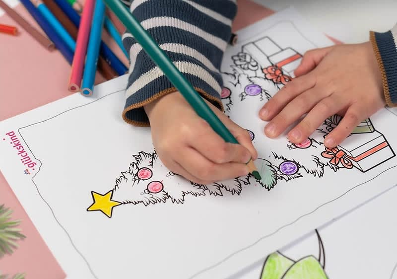 Kind malt Weihnachtsbaum aus.