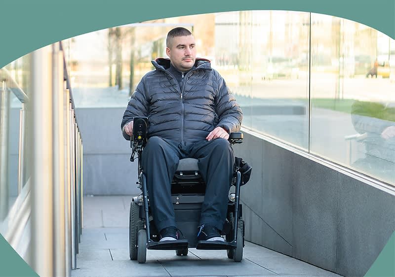 Person im Rollstuhl auf Rampe.