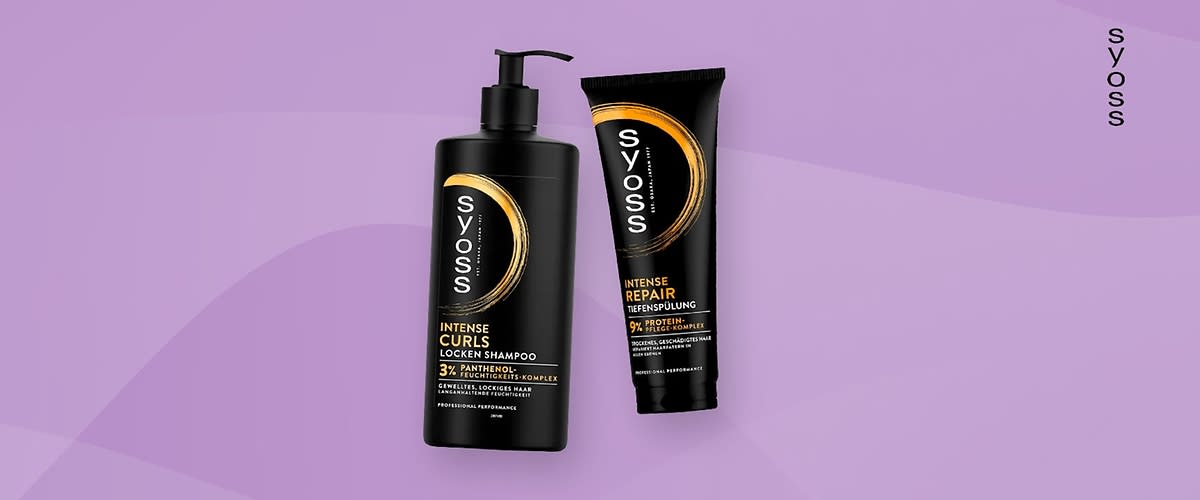 Zwei schwarze Produktverpackungen der Marke Syoss auf einem lila Hintergrund, links eine Flasche mit Pumpspender und der Aufschrift Intense Curls Locken Shampoo, rechts eine Tube mit der Aufschrift Intense Repair Tiefenspülung, beide Verpackungen tragen das Syoss-Logo in Weiß und Gold, der Markenname Syoss ist auch vertikal am rechten Bildrand zu sehen.