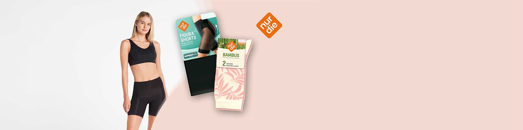 Zwei verpackte Produkte der Marke „nur die“ auf hellem Hintergrund: links eine schwarze Packung mit Bild einer Frau in schwarzen Figur-Shorts und Aufschrift „FIGURA SHORTS“, rechts ein Paar rosa-weiß gemusterter Bambus-Socken in Kartonbanderole mit Aufschrift „BAMBUS 2 SOCKEN“ und dem orange-weißen „nur die“-Logo