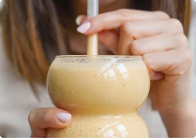 Frau trinkt gelben Smoothie